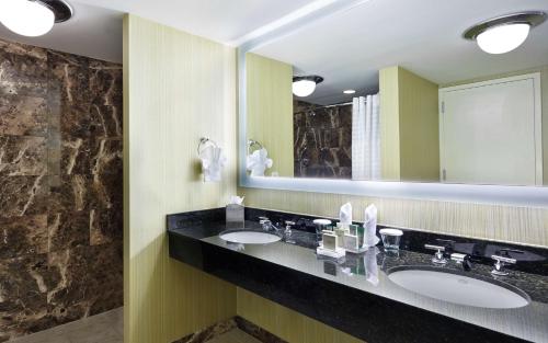 a bathroom with two sinks and a large mirror at Hilton Newark Airport in Elizabeth