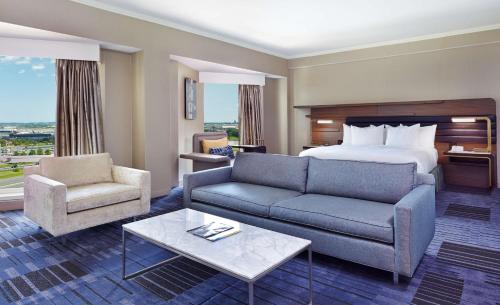 a hotel room with a bed and a couch and a table at Hilton Newark Airport in Elizabeth