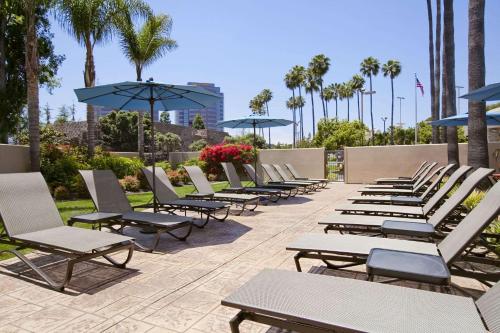 a row of lounge chairs and umbrellas on a patio at Embassy Suites by Hilton San Diego La Jolla in San Diego