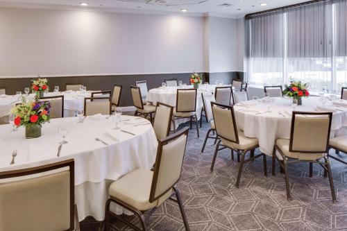 a banquet room with white tables and chairs and flowers at Hilton Newark Airport in Elizabeth