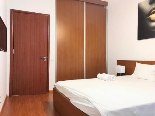 a bedroom with a bed and a wooden door at Orange Onix Apartaments in Bucharest