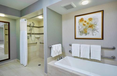 a bathroom with a white tub and a shower at DoubleTree by Hilton Washington DC – Crystal City in Arlington