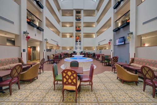 eine große Lobby mit Tischen, Stühlen und einem Tisch in der Unterkunft Hampton Inn & Suites By Hilton - Rockville Centre in Rockville Centre