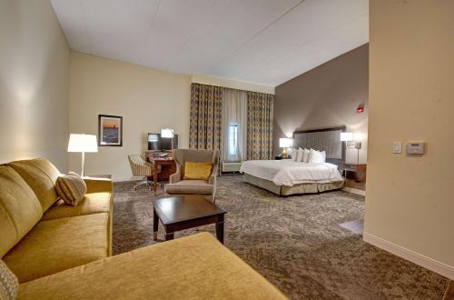 a hotel room with a bed and a desk at Hampton Inn & Suites By Hilton - Rockville Centre in Rockville Centre