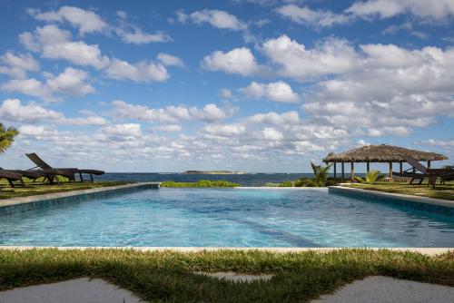 a swimming pool with a view of the ocean at YellowBird home in South Palmetto Point