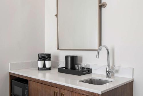 a kitchen counter with a sink and a mirror at Embassy Suites by Hilton Charleston Harbor Mt. Pleasant in Charleston