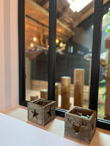 deux caisses métalliques assises sur un rebord de fenêtre dans l'établissement Stone Lake Luxury Lodge, à Gérardmer