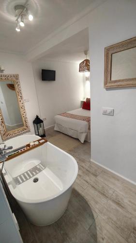 baño con bañera blanca y cama en La Damajuana, Casa Rural en Montejaque