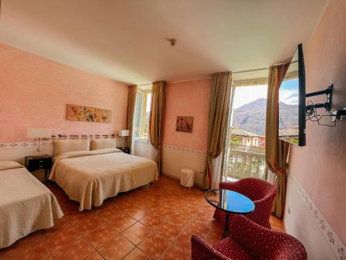 pokój hotelowy z dwoma łóżkami i oknem w obiekcie Caroline Hotel w mieście Brusimpiano