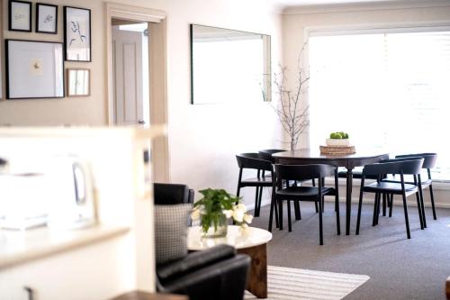 ein Esszimmer mit einem schwarzen Tisch und Stühlen in der Unterkunft Popular Central Location I NEW LINEN I Gated Estate I STAY DUBBO in Dubbo