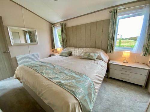 a bedroom with a large bed with a window at The Lodge in Selsey