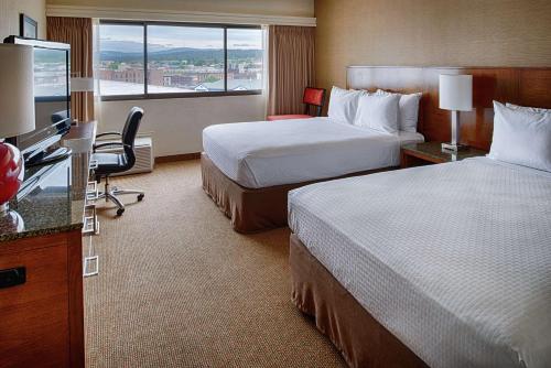 a hotel room with two beds and a flat screen tv at DoubleTree by Hilton Spokane City Center in Spokane