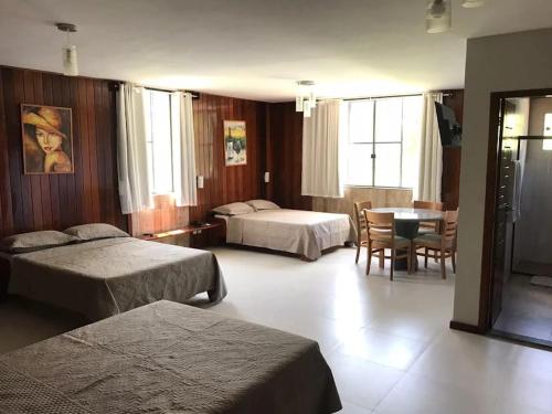 a hotel room with two beds and a table at Hotel Fazenda Valaisan in Santa Maria Madalena