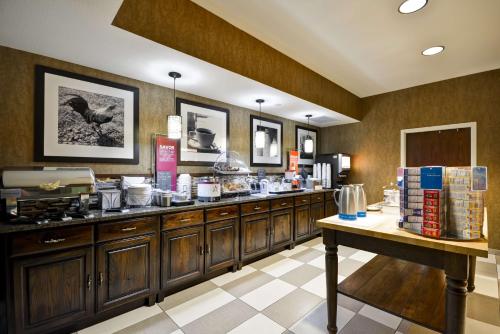 a kitchen with wooden cabinets and a counter with food at Hampton Inn Bozeman in Bozeman