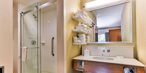 a bathroom with a sink and a shower with a mirror at Hampton Inn Charleston-Daniel Island in Charleston