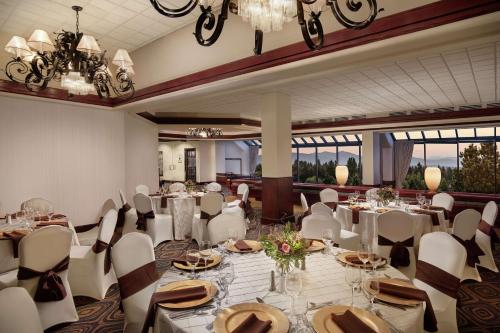 a banquet room with white tables and chairs and chandeliers at DoubleTree by Hilton Seattle Airport in SeaTac