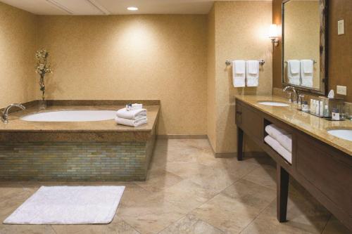 a large bathroom with a tub and two sinks at DoubleTree by Hilton Seattle Airport in SeaTac