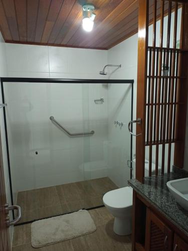 a bathroom with a shower and a toilet and a sink at Hotel Fazenda Valaisan in Santa Maria Madalena