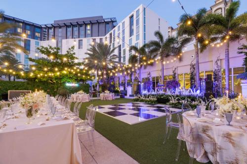 an event venue with tables and chairs in front of a building at Hilton West Palm Beach in West Palm Beach