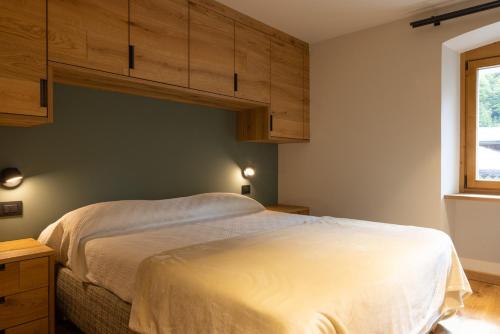 a bedroom with a large bed with wooden cabinets at Maison Luboz - Courmayeur in Courmayeur