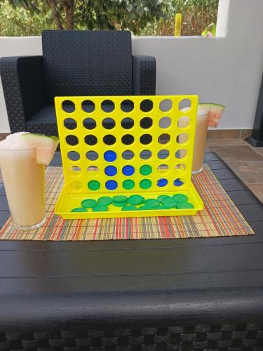 a yellow ping pong game on a table with two drinks at Casa Azul Mountain Retreat in Vega de San Mateo