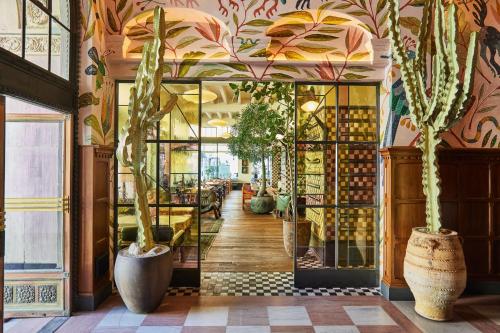 a room with potted plants and a wall of windows at Downtown Los Angeles Proper Hotel, a Member of Design Hotels in Los Angeles