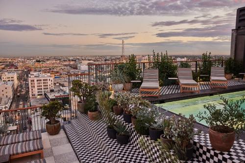 a balcony with chairs and plants on a building at Downtown Los Angeles Proper Hotel, a Member of Design Hotels in Los Angeles