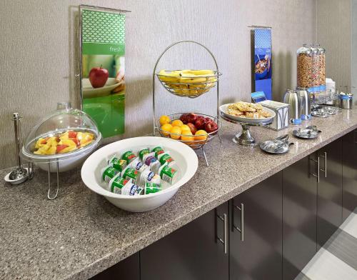a counter with bowls of fruit and other food on it at Hampton Inn by Hilton Calgary Airport North in Calgary