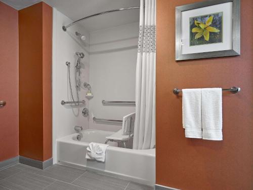 a bathroom with a tub and a shower with towels at Hampton Inn by Hilton Calgary Airport North in Calgary