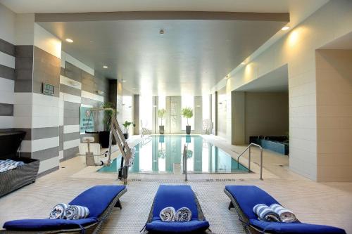 a swimming pool with blue lounge chairs in a building at Hilton Columbus Downtown in Columbus