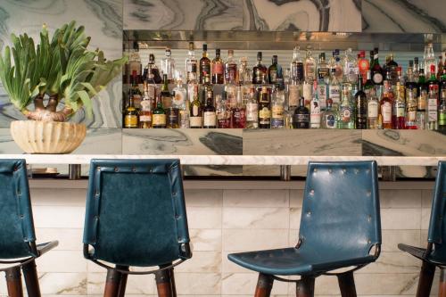 a bar with two chairs in front of a bar at Avalon Hotel Beverly Hills, a Member of Design Hotels in Los Angeles