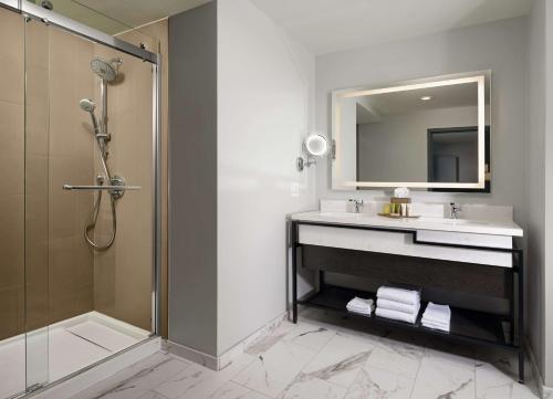 a bathroom with a sink and a shower and a mirror at Hilton San Jose in San Jose