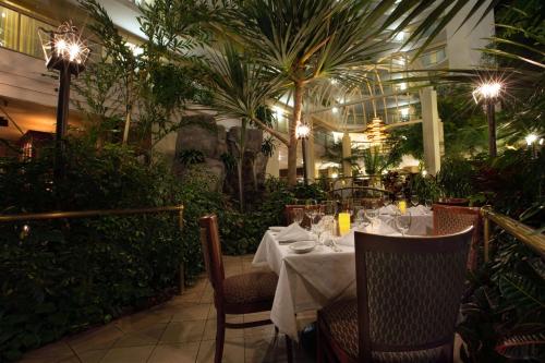 a dining room with a table and chairs and plants at Embassy Suites Birmingham in Birmingham