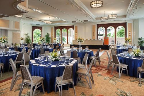 a ballroom with tables and chairs with blue linens at Moana Surfrider, A Westin Resort & Spa, Waikiki Beach in Honolulu