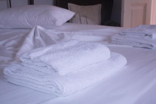 a group of towels sitting on top of a bed at Your Holiday Apartment in Kavála