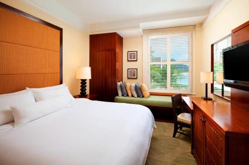 a bedroom with a bed and a desk and a television at Moana Surfrider, A Westin Resort & Spa, Waikiki Beach in Honolulu