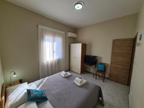 Casa Nautilus - 30m dal mare في لامبيدوسا: غرفة نوم فيها سرير وتلفزيون