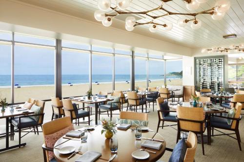 um restaurante com mesas e cadeiras e a praia em Waldorf Astoria Monarch Beach Resort & Club em Dana Point