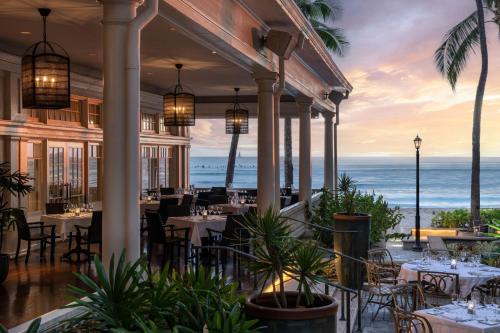 a restaurant with tables and chairs with the ocean in the background at Moana Surfrider, A Westin Resort & Spa, Waikiki Beach in Honolulu