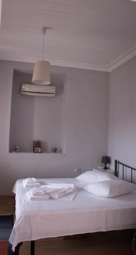 a bedroom with a white bed with towels on it at Your Holiday Apartment in Kavála