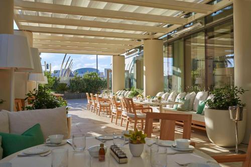 un restaurante con mesas y sillas en un patio en Waldorf Astoria Beverly Hills en Los Ángeles