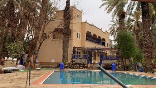 un edificio con piscina frente a una casa en Gite D'Etape Amced, en Goulmima