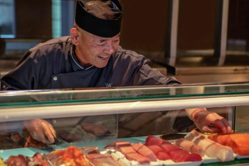 a chef preparing food behind a glass counter at Waldorf Astoria Las Vegas in Las Vegas