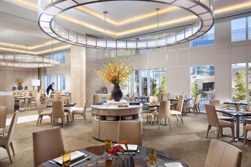 a restaurant with tables and chairs and a large chandelier at Waldorf Astoria Las Vegas in Las Vegas