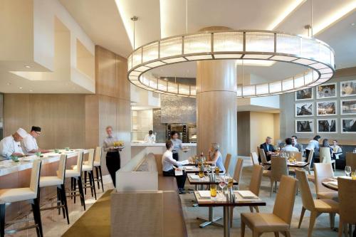 a restaurant with people sitting at tables and a bar at Waldorf Astoria Las Vegas in Las Vegas