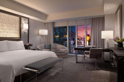 a hotel room with a large bed and a desk at Waldorf Astoria Las Vegas in Las Vegas