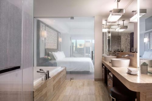 a bathroom with a bed and a tub and a sink at Waldorf Astoria Las Vegas in Las Vegas