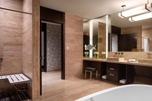 a bathroom with a tub and a large mirror at Waldorf Astoria Las Vegas in Las Vegas