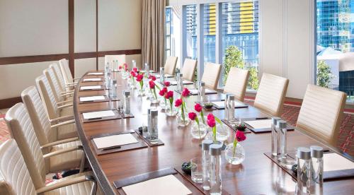 a long table with chairs and vases with red flowers at Waldorf Astoria Las Vegas in Las Vegas