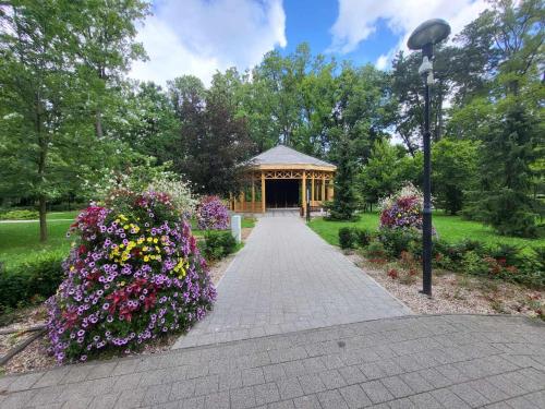 a gazebo in a park with flowers at Aquarius Kilińskiego 3 in Grodzisk Mazowiecki